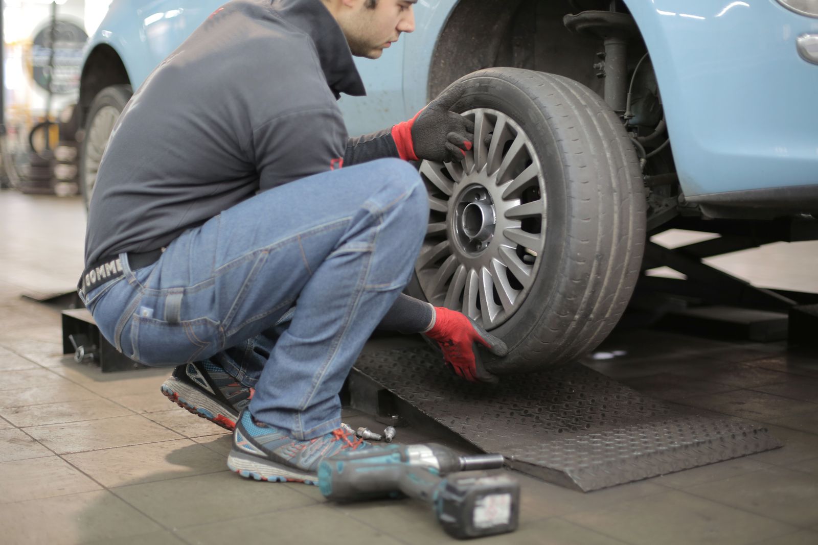 Close view of a passenger-car alloy wheel and lug nuts
