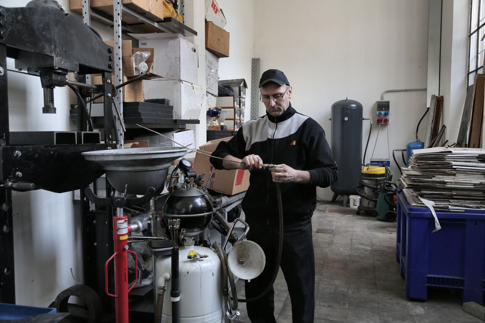 Technician using a powered tool on a vehicle in a shop