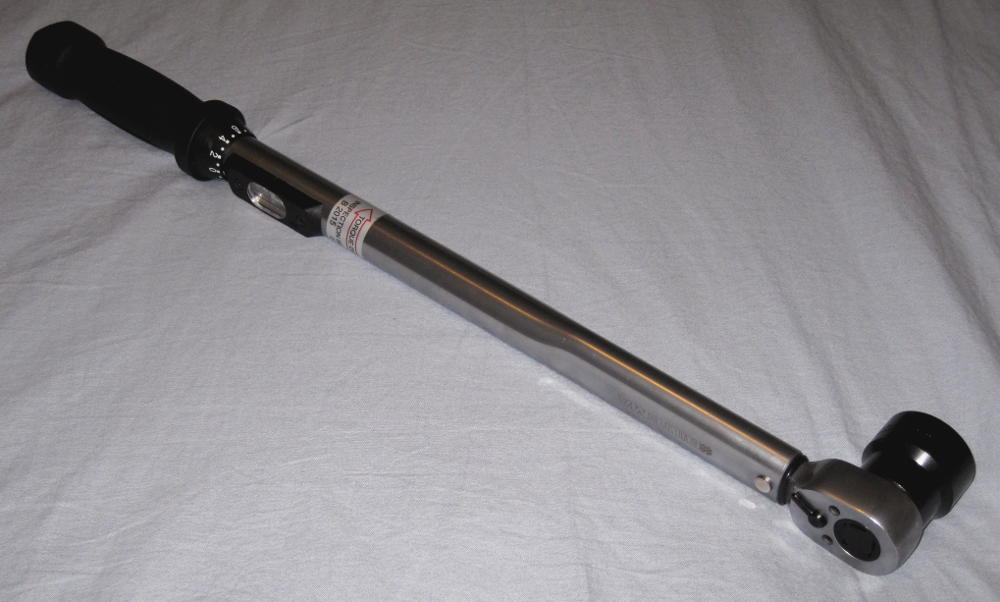 Adjustable torque wrench with a dual-scale window for newton-meters and foot-pounds