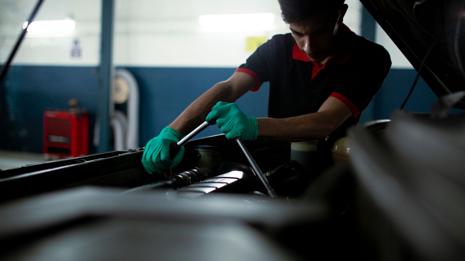 Mechanic using a torque wrench on a car engine
