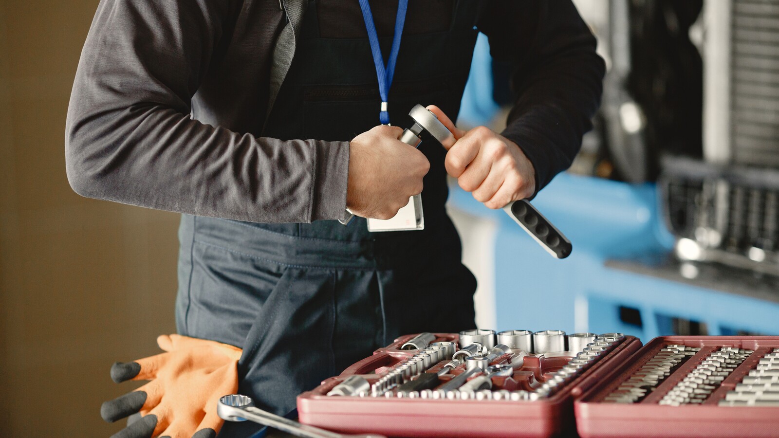 Mechanic handling a hand tool beside an organized socket set